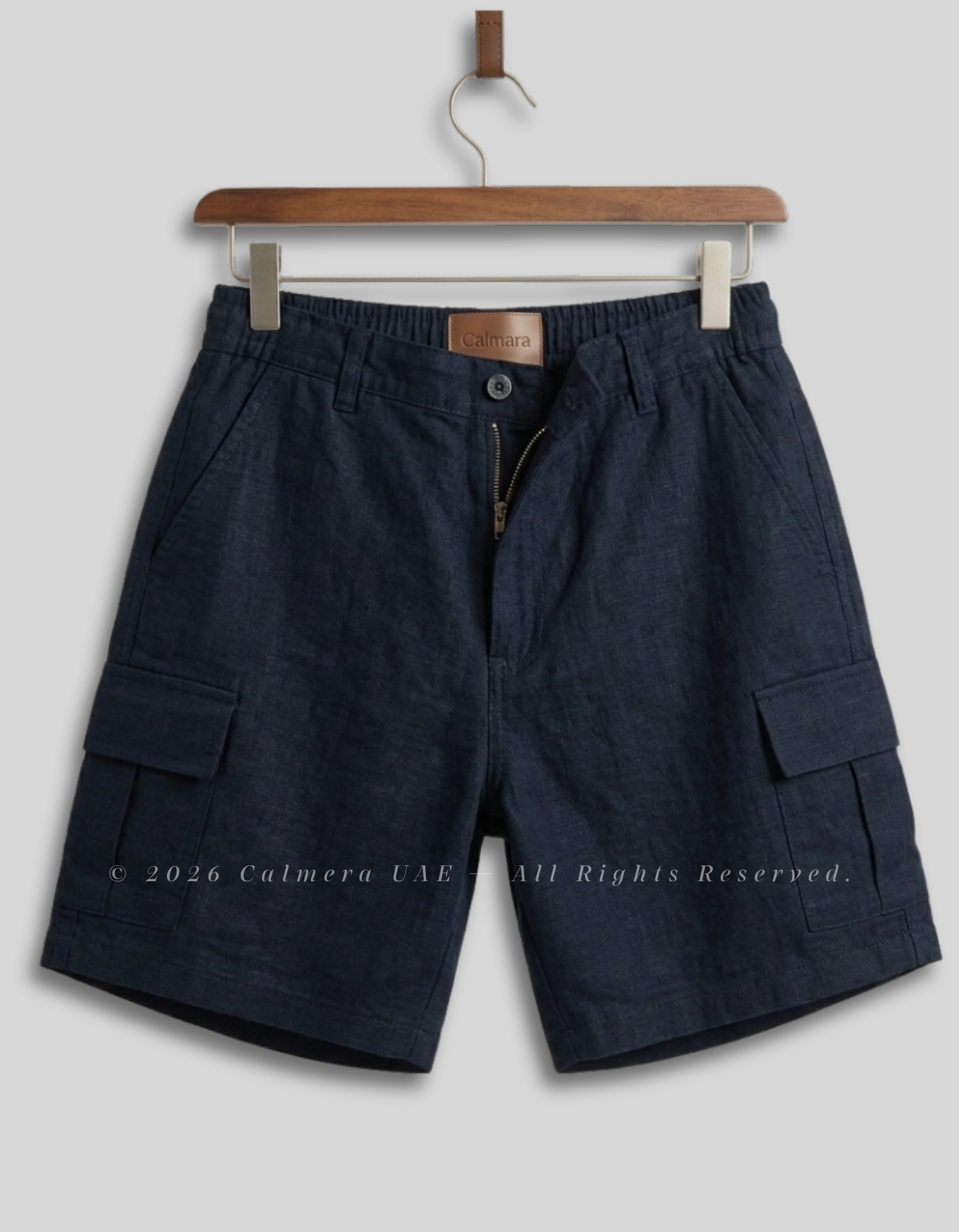 Dark navy blue cargo shorts with an elastic waistband, hanging on a wooden hanger against a light gray background.
