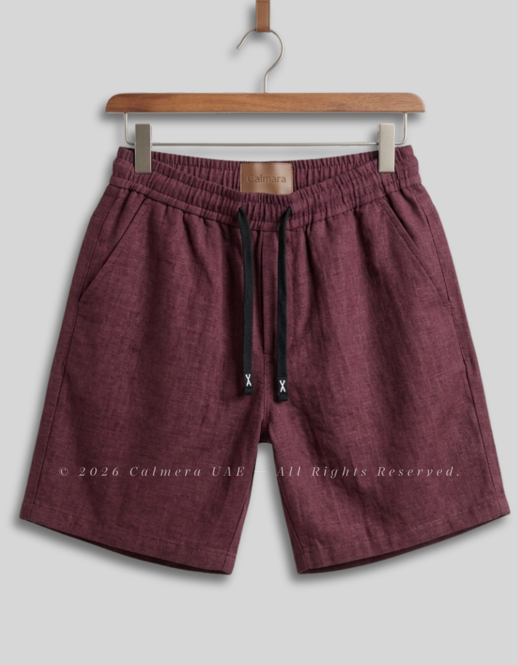 Calmera men's maroon linen drawstring shorts front view on hanger